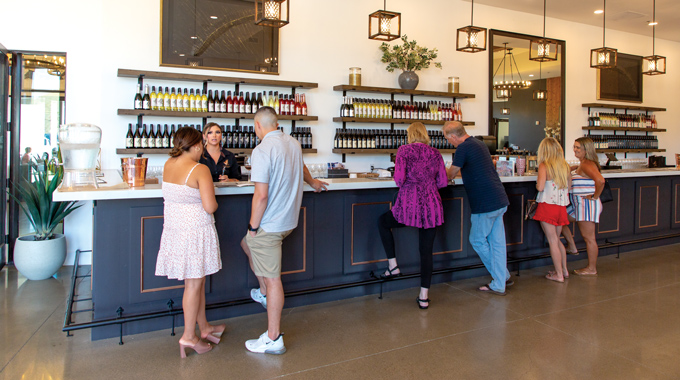 People at the counter inside the Altisima Winery tasting room