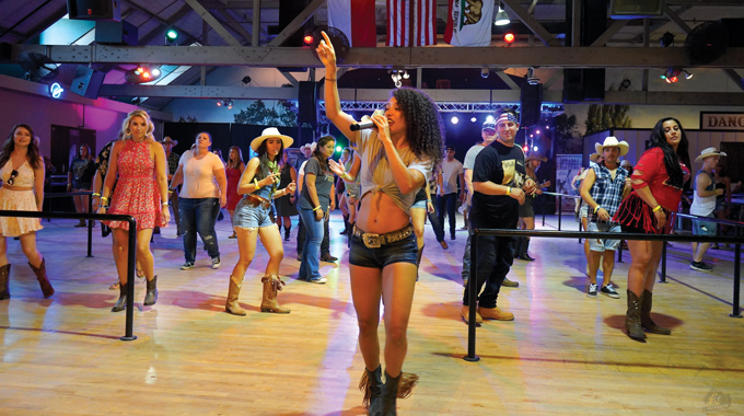 A woman leading a group line-dancing lesson at the Temecula Stampede