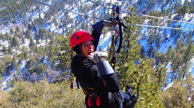 A zipliner dangles 300 feet above the ground