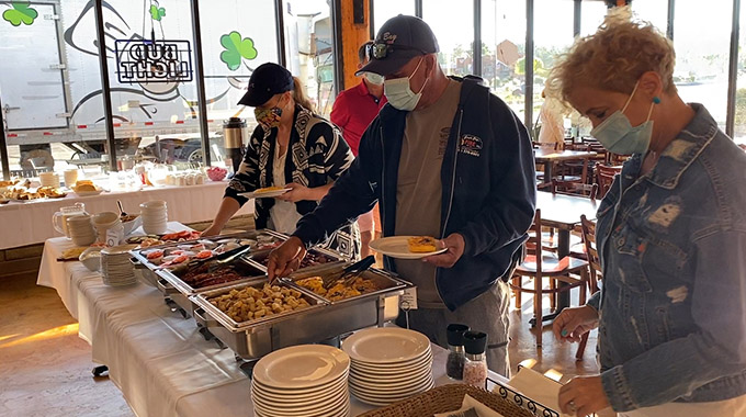 The members of the Enchanting Canyonlands tour group serve themselves breakfast in Tusayan, Arizona