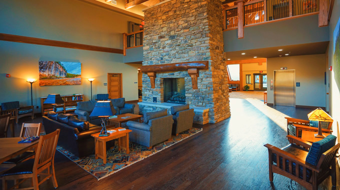 Chairs and tables in front of a fireplace at Echo Bluff State Park Lodge