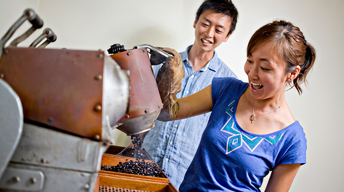 Roasted Kona coffee is poured out of the mini-roasting barrel. 