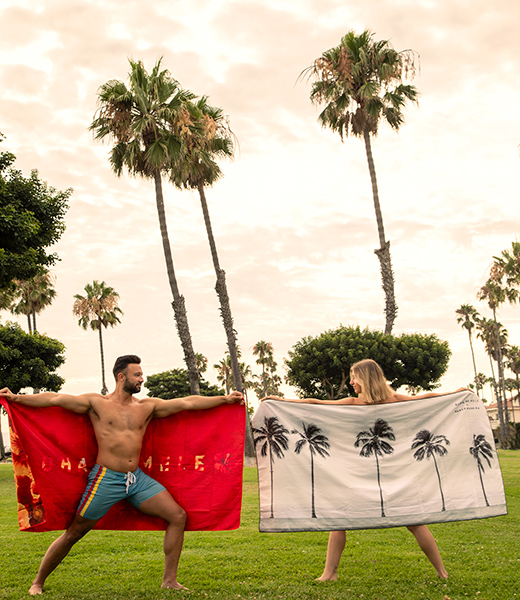 Man and woman holding up Aloha de Mele microfiber towels.