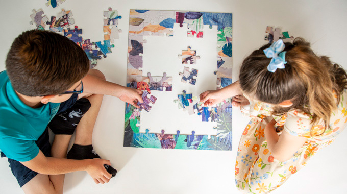 Two children putting together a jigsaw puzzle.