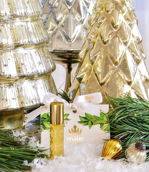 Mālie's roll-on perfume set among holiday decorations.