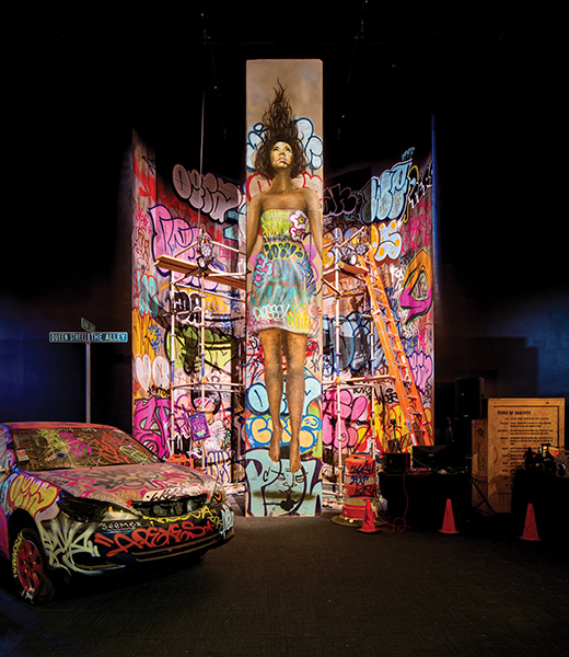 Hawai’i artists Kamea Hadar and Sean “Hula” Yoro’s striking mural of a woman gazing skyward dominates a Bishop Museum gallery. Local and visiting artists graffitied the surrounding space. | Photo by Brandon Shigeta