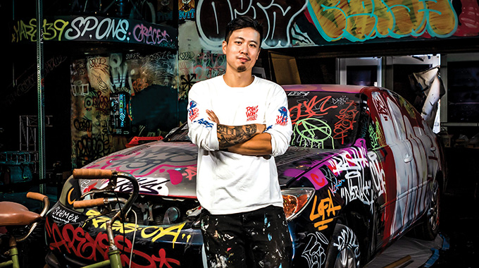 Hawai‘i muralist Jasper Wong at a 2021 Bishop Museum exhibition commemorating the 10th anniversary of the Pow! Wow! street-mural festival. | Photo by Lance Aquino