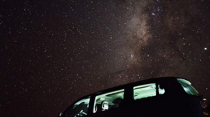 The Milky Way shining in the sky above a parked vehicle.
