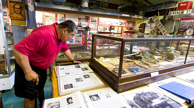 A visitor at Hawai‘i Plantation Museum on Hawai‘i Island reads a plantation newspaper from his parents’ generation. 