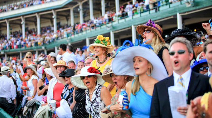 Kentucky Derby spectators clad in blazers, dresses, and eye-catching hats.