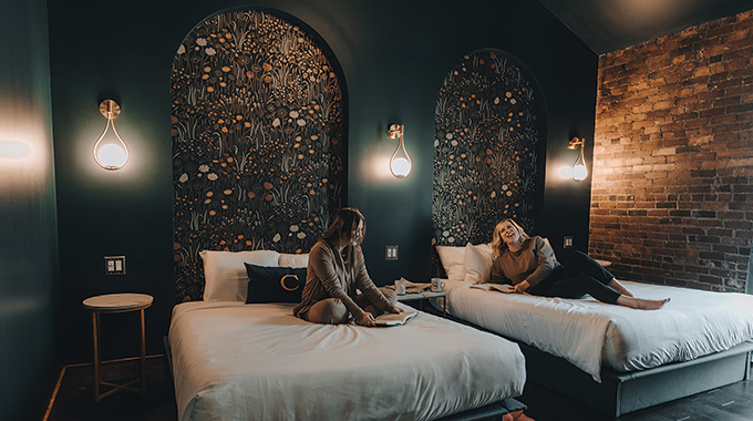 Guests lounging on their beds inside the Chandler Hotel.