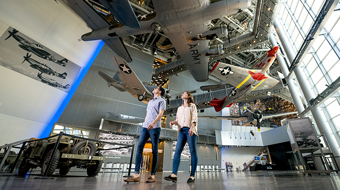 People walking through the National WWII Museum, with aircraft overhead