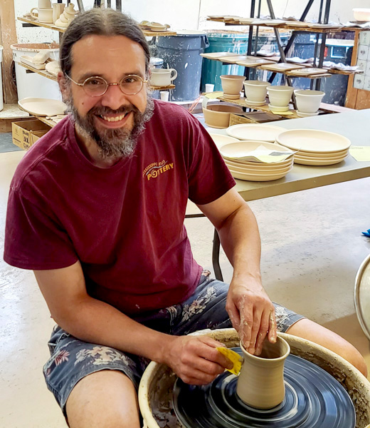 Chad Nelson working at a pottery wheel.