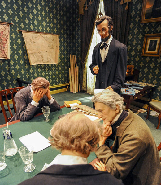 A life-size model of Abraham Lincoln watching his cabinet react to his plans to issue the Emancipation Proclamation