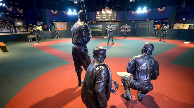 Statues of legendary Black baseball players positioned around a mock baseball diamond
