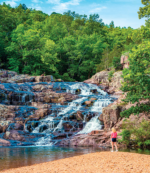 Woman admiring Rocky Falls from the shore