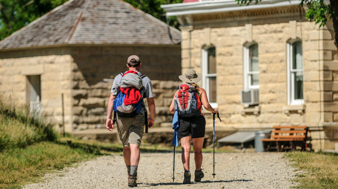 Two hikers walking toward a structure at the Tallgrass Prairie National Preserve