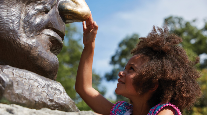 A young visitor at the Lincoln Tomb State Historic Site, where rubbing the nose on a bust of Lincoln is said to bring good luck. | Photo courtesy The Illinois Office of Tourism