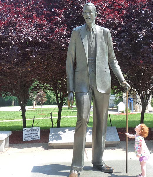 Young girl looking up at a statue of Robert Wadlow