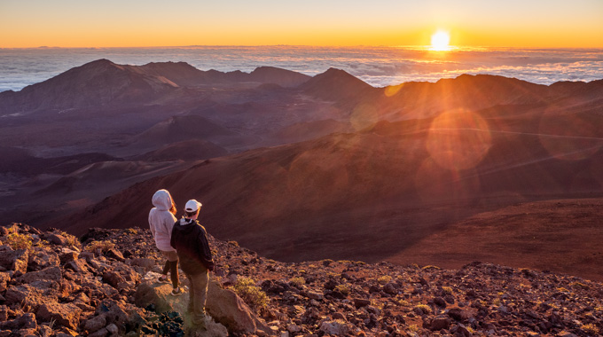 A couple watching the sunrise at Haleakala National Park in Maui, Hawaii