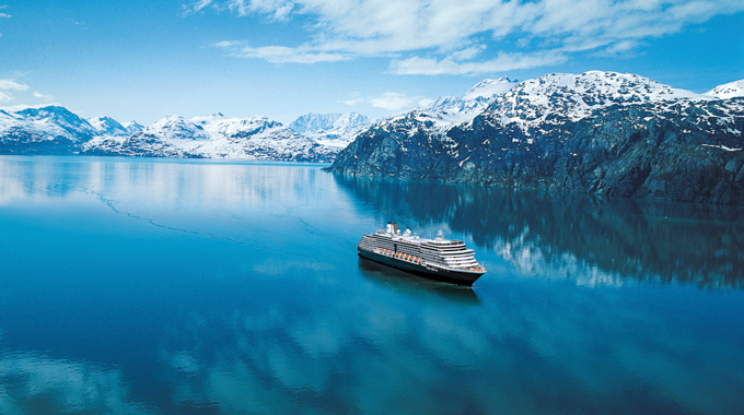 A cruise ship sailing beside glaciers