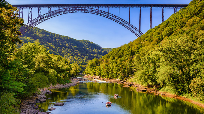 New River Gorge Bridge kayakers passing underneath the New River Gorge Bridge