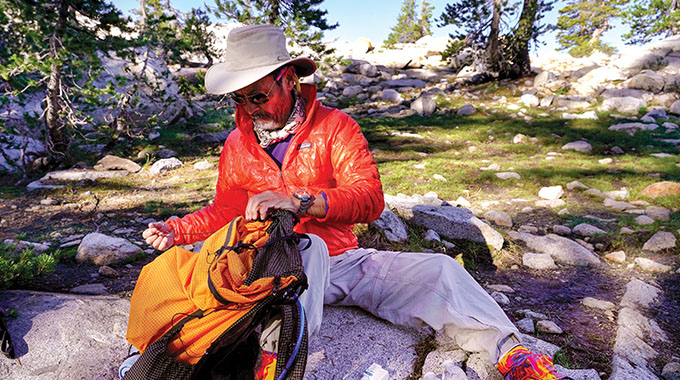 A hiker in Yosemite National Park takes advantage of a break to repair gear. 