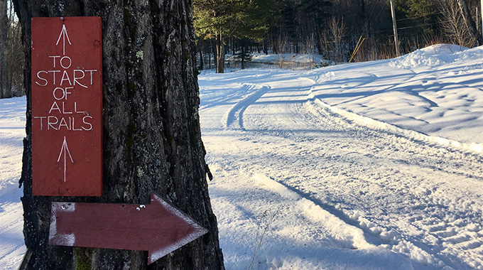 Rustic signs point skiers and snowshoers along trails that wind through orchards and forested public lands at Maine’s Five Fields Farm. | Photo courtesy Five Fields Farm