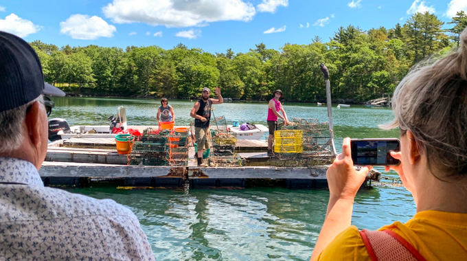 Oyster farmers waving to passengers on a Damariscotta River cruise