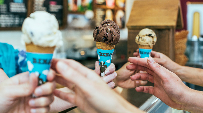 People reaching for cones with scoops of Ben & Jerry's ice cream 
