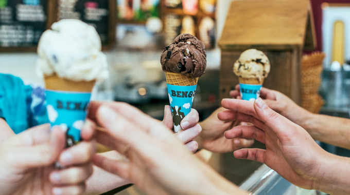 People reaching for cones with scoops of Ben & Jerry's ice cream