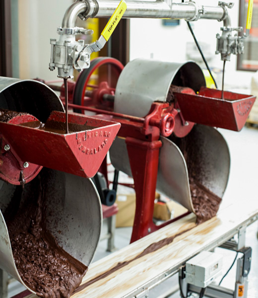 Chocolate flowing into a machine at Taza Chocolate