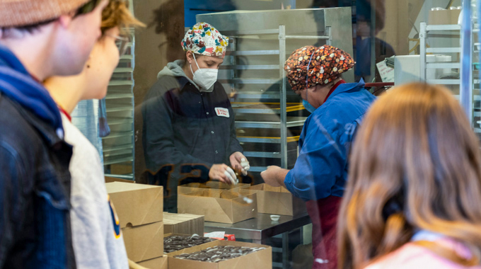 Visitors watching chocolatiers during a tour at Wilbur's of Maine Chocolate Confections