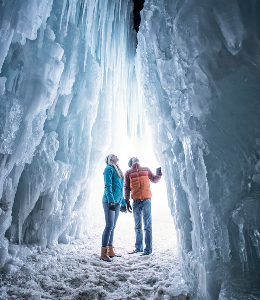Couple gazing upward at the frozen scenery at Ice Castles.