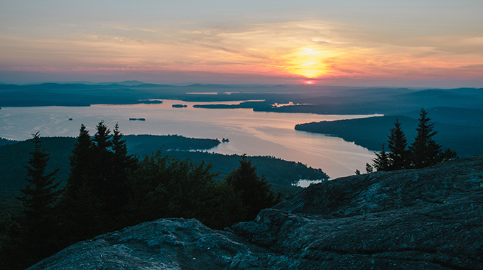 A sunrise view over Lake Winnipesaukee rewards morning hikers at Mount Major. | Photo by Emily Lord/Forest Society