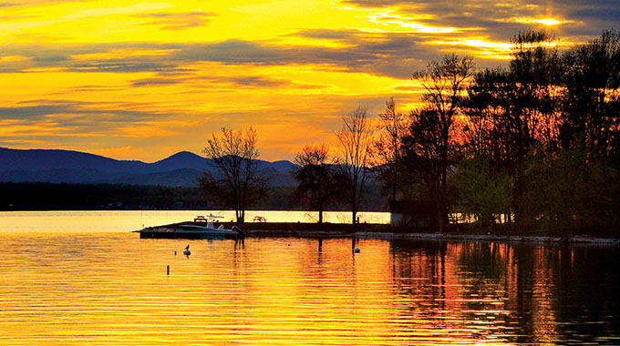 Catch a spectacular Lake Champlain sunset while relaxing on a rented houseboat. | Photo by Pat and Chuck Blackley/Alamy Stock Photo