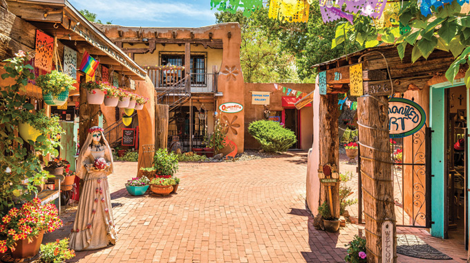 A brick-lined walkway leading to adobe buildings in Albuquerque's Old Town