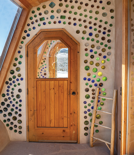 Earthship wall studded with glass bottles