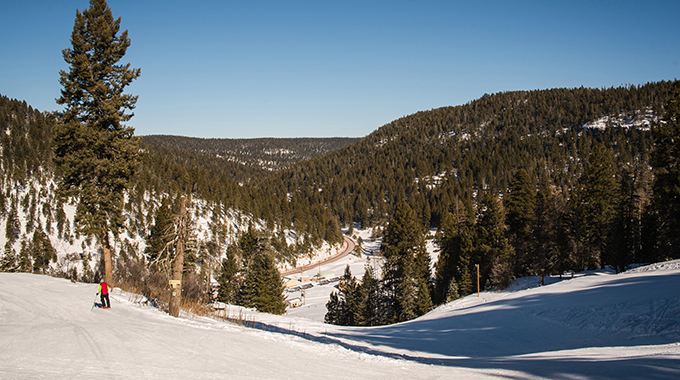 Snow blankets the tree-lined mountainsides at Cloudcroft