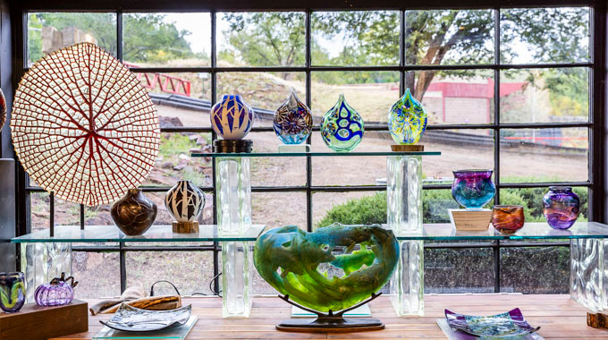 Glass sculptures displayed in the window at Tesuque Glassworks.