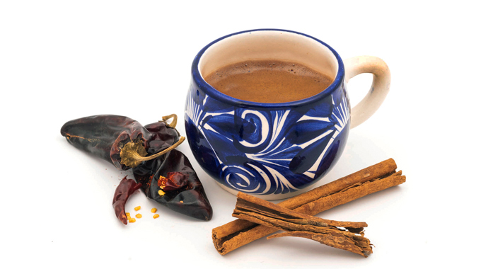 A serving of a Kakawa chocolate elixir served in a blue ceramic mug