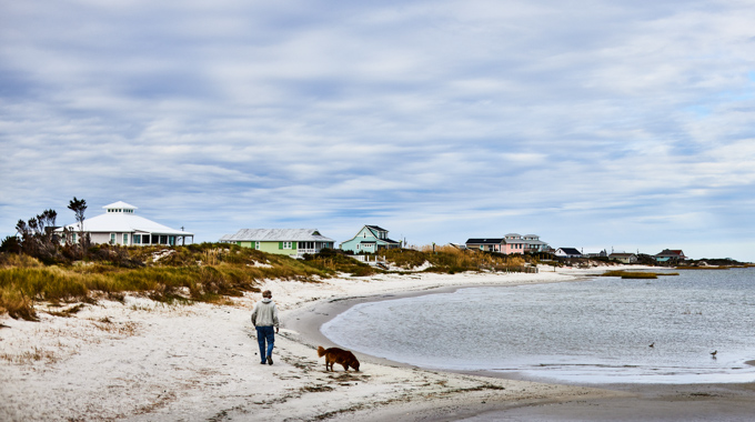 Man and dog walking on Cedar Island beach.