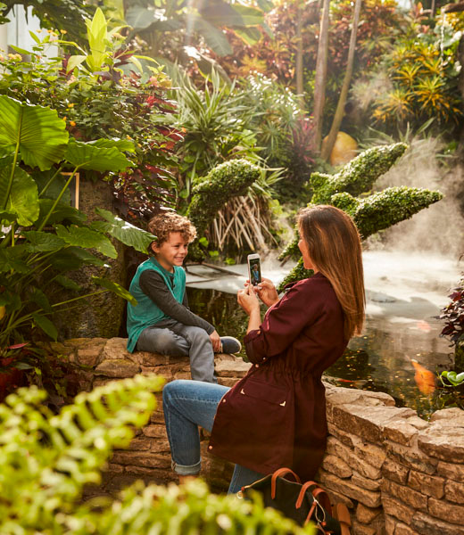 Woman taking a photo of her son at Franklin Park Conservatory and Botanical Gardens