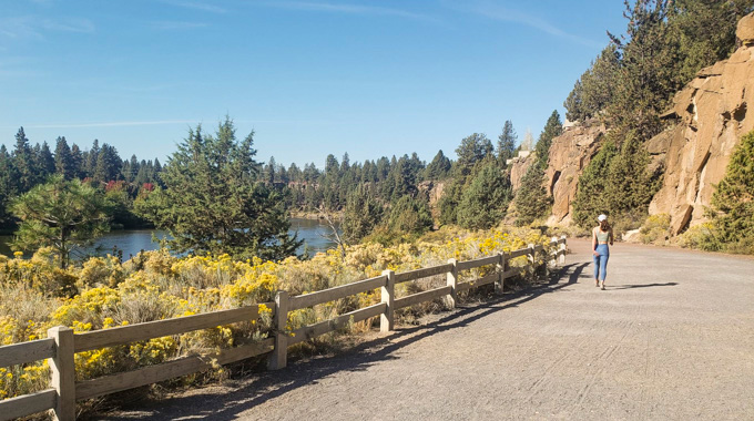 Woman walking on a trail beside the Deschutes River