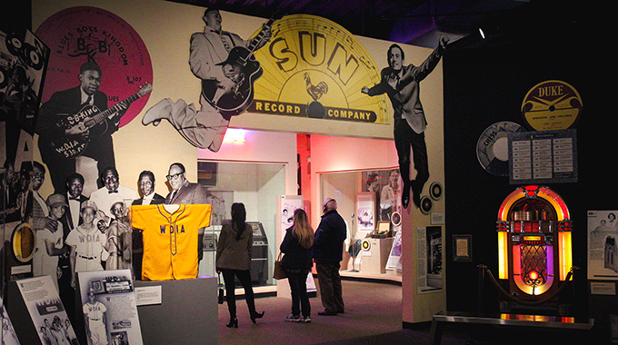 Visitors looking up at a Sun Record Company sign at the Rock ‘n’ Soul Museum.