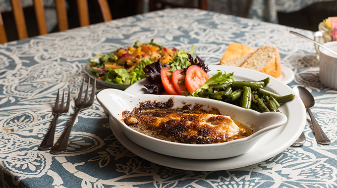 Catfish dish with sides of green beans and salad at The Crown.