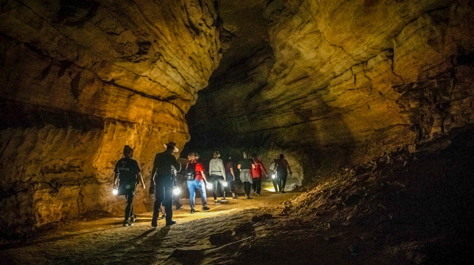 Hikers carrying lights as they walk through Mammoth Cave National Park