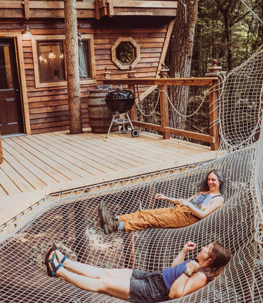 Guests lounge in hammocks outside the Sky Dancer treehouse