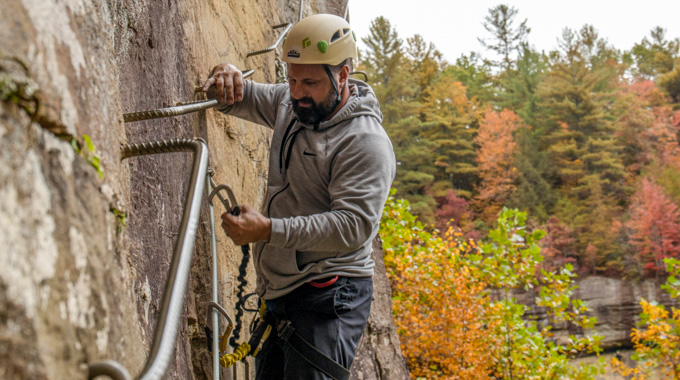 Man securing his carabiner to the via ferrata