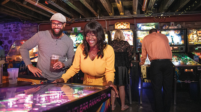 Couples playing the pinball machines at Pinpoint Fayetteville.